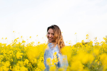 A happy girl in a meadow of yellow flowers