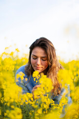Naklejka na ściany i meble A happy girl in a meadow of yellow flowers