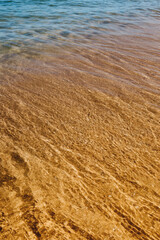 Fototapeta na wymiar Areia e água do mar com onda batendo
