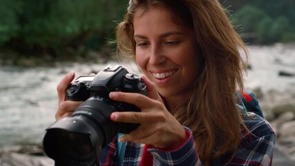 Woman holding photo camera in hands. Female photographer using digital camera