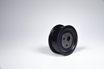 Close-up of a timing belt idler one against a gray background. New spare parts for a car internal combustion engine