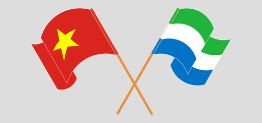 Crossed and waving flags of Vietnam and Sierra Leone