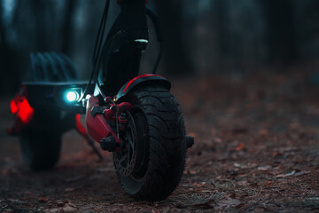 Powerful modern all-wheel drive electric scooter in the evening with the parking lights on....