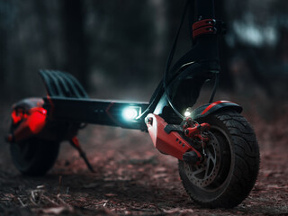 Powerful modern all-wheel drive electric scooter in the evening with the parking lights on....