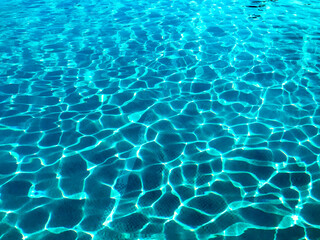 Pattern formed by rippling water on an outdoor swimming pool. No people.