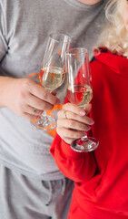 couple in home sportswear holding glasses of champagne