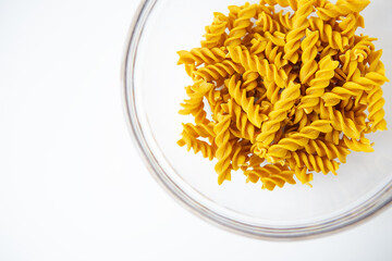 Fusilli pasta in a plate close-up on a white plate. Natural pasta made from hard wheat with the addition of pumpkin.