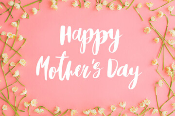 Fototapeta na wymiar Happy mother's day. Happy mother's day text and spring flowers frame flat lay on pink paper. Stylish floral greeting card. Handwritten lettering on white spring snowflakes on pink. Mothers day