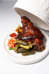 Baked appetizing icebein with vegetables on a white plate