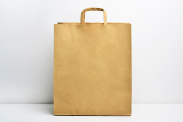 Kraft brown paper shopping bag. Paper shopping bag on white background. Brown paper craft bag isolated on white background. Recycled paper shopping bag. Mock-up of blank craft package. 