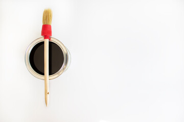 Paint symbol. A round paint brush lies on a can of paint on a white background. Copy space. Business and paint concept.