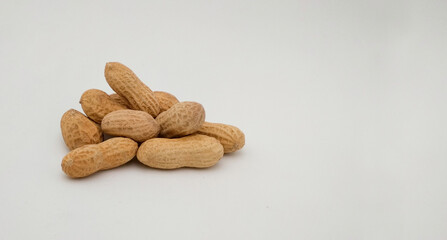 organic peanuts in shell (Arachis hypogaeaon) on white background with copy space
