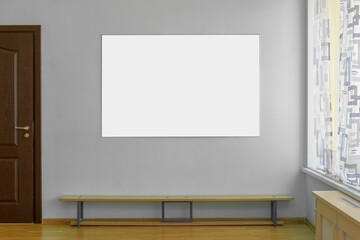 Empty white sign board hangs on concrete wall of gym indoor.