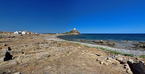 Uncovered excavations with an old tower in the background near the town of Nora on the island of Sardinia