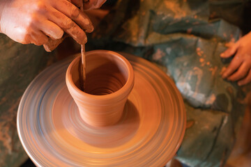 Fototapeta na wymiar Potter's hands. Making clay products on a potter's wheel. Pottery master class.
