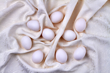 Fototapeta na wymiar Pile of chicken eggs on a white curtain.