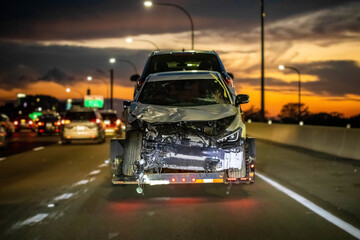 Fototapeta na wymiar Loaded broken car on a tow truck after crash
