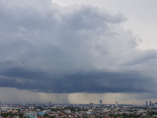 Rain clouds are falling far in the city.