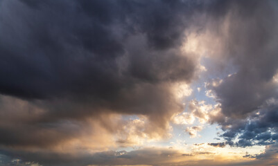 Obraz premium Sunset sky background. Beautiful sunset after rain, with bright orange dramatic clouds.