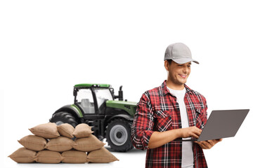 Farmer with a tractor working on a laptop computer