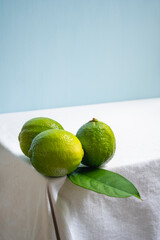 limes on white table and blue background