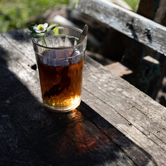 Cup of tea and wild strawberries on a wooden background