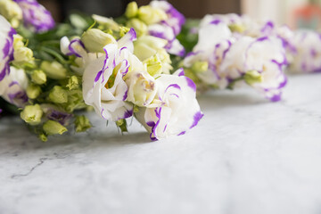 green and white eustoma flowers bouquet.white and violet lisianthus flowers on marble background. background special ocasion, event. Copy space