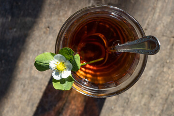 Cup of tea and wild strawberries on a wooden background