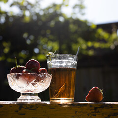 Cup of tea and wild strawberries on a wooden background