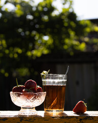 Cup of tea and wild strawberries on a wooden background