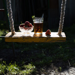 Cup of tea and wild strawberries on a wooden background
