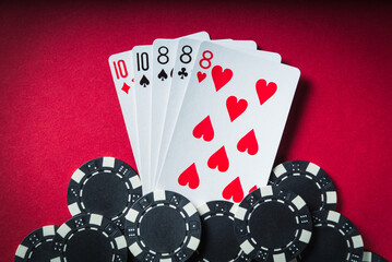 Obraz premium The winning poker combination is full house or full boat. Chips and cards on red table in poker club