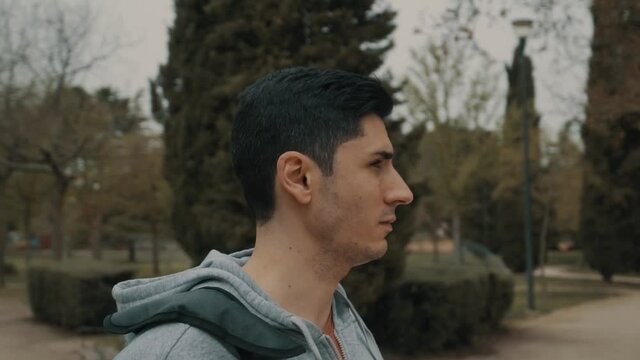 hombre de pelo negro mirando el parque de calistenia, c&aacute;mara girando alrededor de deportista en el parque, hombre musculoso mirando a la gente del parque