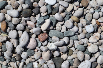 Colorful large pebbles on the beach of mediterranean sea closeup