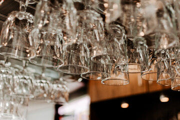 Clean wine glasses hanging on a bar rack at a restaurant