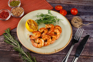butter garlic fried shrimp sprinkled with chili and parsley on a white platter, on a wooden table