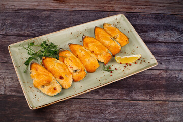 butter garlic fried shrimp sprinkled with chili and parsley on a white platter, on a wooden table