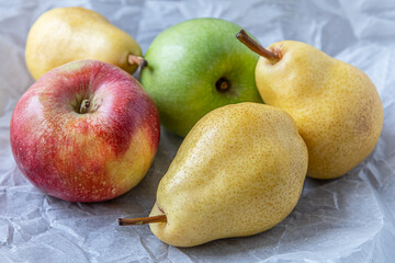 ripe juicy apples and pears on white parchment