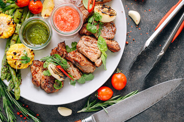 shish kebab and vegetables grilled and served on a white plate