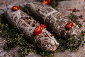 Assorted brown meat with peppers and spices on a light parchment background. Seasonings for food. Homemade spices ingredients for cooking. Selective focus