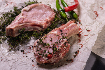 Assorted brown meat with peppers and spices on a light parchment background. Seasonings for food. Homemade spices ingredients for cooking. Selective focus