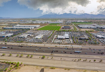 Obraz premium Aerial top view of typical a Avondale small town shopping center with big parking lot a major freeway near Phoenix Arizona USA