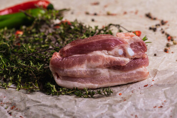 Raw fresh beef ribs steak with seasoning on a light surface, parchment, before cooking. Seasoning for meat steak with ribs for eyes rosemary, coriander, pepper. Top view, lying flat