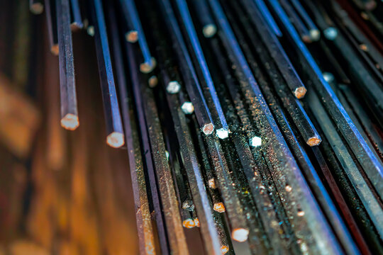 metal rods in mass in a warehouse, end view, metallurgy, steel, blurred background - Powered by Adobe