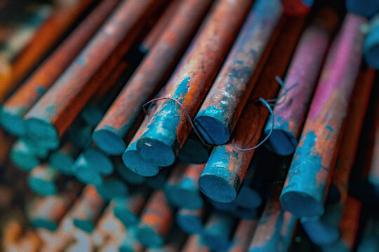 metal rods with rust in bulk, metallurgy, steel, blurred background - Powered by Adobe