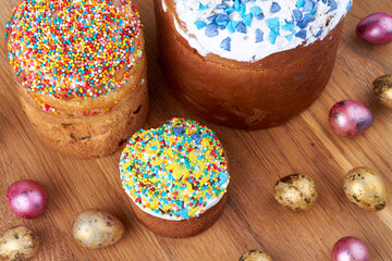 Top view easter cupcakes with icing and eggs on brown wooden surface.