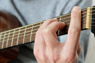 Fototapeta na wymiar Left hand playing an F chord on guitar