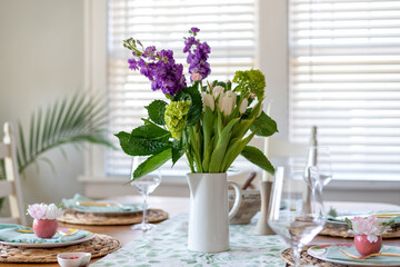 Stylish spring table setting with fresh flower bouquet for centerpiece