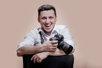 Close up portrait of woman photographer with camera taking pictures with digital camera on brown background