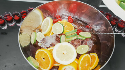 Mixed punch with fresh fruits in metal bowl